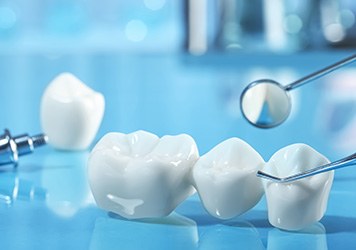 Dental bridge and implant one reflective blue surface next to dental instruments