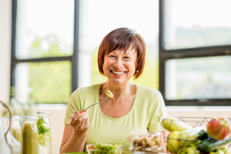 Older patient eating food with dentures